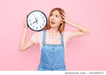 A shocked , nervous young lady on an isolated pink A shocked , nervous young lady on an isolated pink 64100453