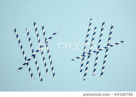 Straws with strips. Monochrome stylish composition in blue color. Top view, flat lay. 64100798