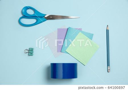 Sticker papers, scissors, pen. Monochrome stylish composition in blue color. Top view, flat lay. 64100897