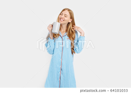 Beautiful girl in striped pajamas, with a Cup in Beautiful girl in striped pajamas, with a Cup in 64101033