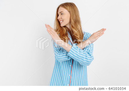 Beautiful girl in striped pajamas, doing hands Beautiful girl in striped pajamas, doing hands 64101034