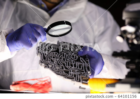 Man examines spare part an automatic transmission Man examines spare part an automatic transmission 64101156