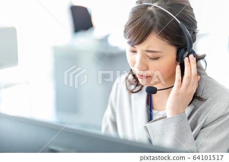A young female operator listening to a complaint A troubled face 64101517