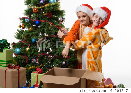 Two girls funny take off toys from a New Year tree 64101847