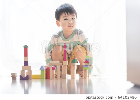 Boy playing with building blocks 64102480