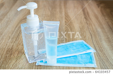 Prevention of infection from the Corona virus. Alcohol gel for washing hands and a sanitary mask on the wooden table,washing hands and wearing a sanitary mask every time to prevent infectio 64103457