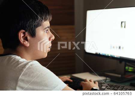 Teenager concentrated is studying at home attending online classes during the coronavirus COVID-19 pandemic quarantine 64105763