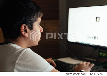 Teenager concentrated is studying at home attending online classes during the coronavirus COVID-19 pandemic quarantine 64105766