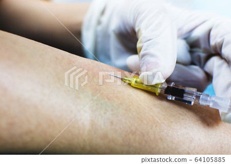 Syringe injecting into a vein on the arm of patient. Syringe injecting into a vein on the arm of patient. 64105885