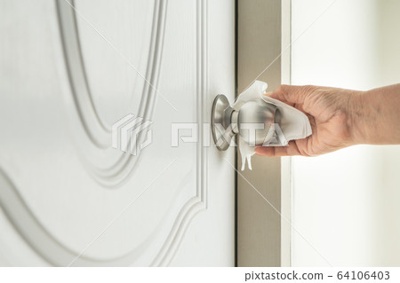 Cleaning door knob with alcohol spray for Covid-19 Coronavirus prevention Cleaning door knob with alcohol spray for Covid-19 Coronavirus prevention 64106403