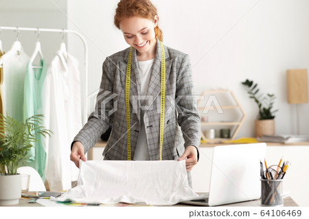 Happy Tailor Girl Working On A New Garment Happy Tailor Girl Working On A New Garment 64106469