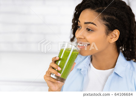 Afro Girl Drinking Smoothie And Looking Away Afro Girl Drinking Smoothie And Looking Away 64106684