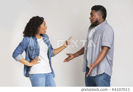 Misunderstanding in relationship. Furious black woman blaming her boyfriend Misunderstanding in relationship. Furious black woman blaming her boyfriend 64107011