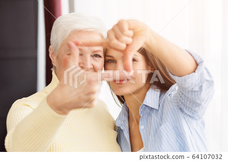 Happy mom and daughter making frame with fingers Happy mom and daughter making frame with fingers 64107032