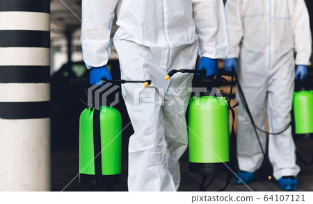 Unrecognizable people in protective hazmats holding spray 64107121