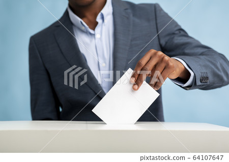 African Man throwing his vote into the ballot box African Man throwing his vote into the ballot box 64107647