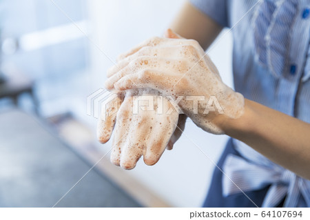 A woman washing her hands 64107694