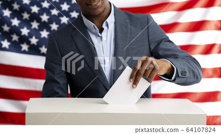 Voter pulls vote ballot. USA flag on background 64107824