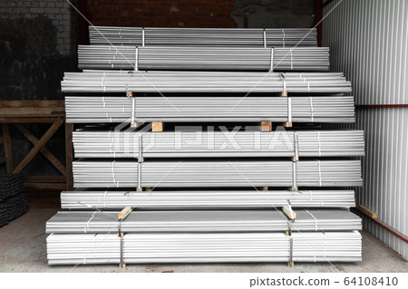 galvanized metal profile packed in stacks at a street warehouse. galvanized metal profile packed in stacks at a street warehouse. 64108410
