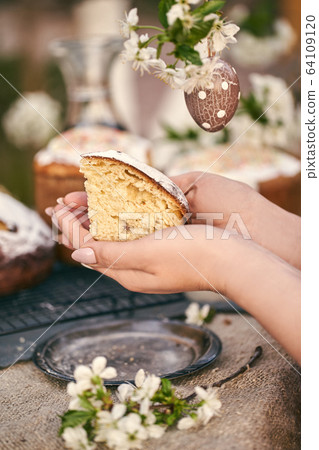 Traditional russian Easter. Woman hands take Orthodox paskha, kulich cakes on table. Traditional russian Easter. Woman hands take Orthodox paskha, kulich cakes on table. 64109120