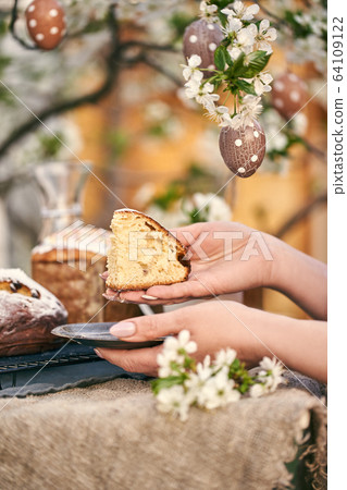 Traditional russian Easter. Woman hands take Orthodox paskha, kulich cakes on table. Traditional russian Easter. Woman hands take Orthodox paskha, kulich cakes on table. 64109122