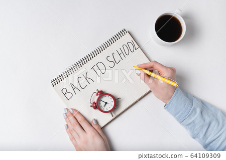 BACK TO SCHOOL written on notebook . Female hands, BACK TO SCHOOL written on notebook . Female hands, 64109309