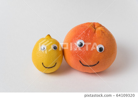 Lemon and orange with funny smiley face on white Lemon and orange with funny smiley face on white 64109320