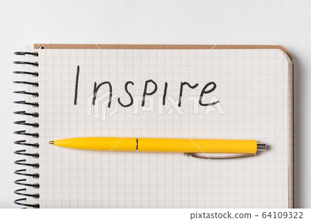 Inscription in copybook INSPIRE. Close up Notepad Inscription in copybook INSPIRE. Close up Notepad 64109322