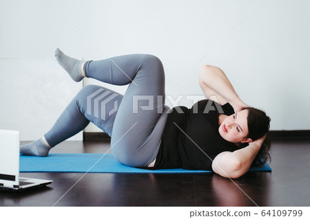 Obese woman doing stretching exercises at home Obese woman doing stretching exercises at home 64109799