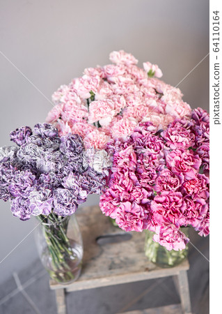 Bunches of carnation flowers different varieties in vases. Lovely Vintage background with flowers. Wallpapers. Clove bunch present for Mothers Day. 64110164