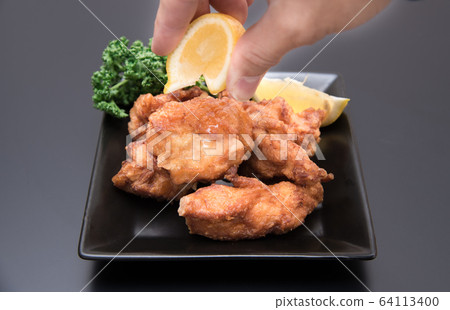 男人的手把檸檬放在炸雞上 男人的手把檸檬放在炸雞上 64113400