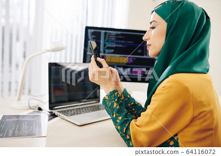 Software developer checking phone 64116072