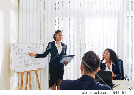 Businesswoman showing diagram to colleagues 64116161