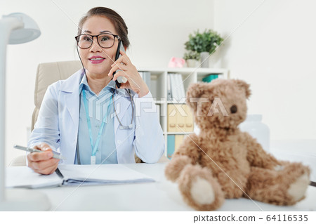 Pediatrician talking on phone Pediatrician talking on phone 64116535