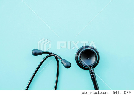 Black modern stethoscope on light blue background. 64121079