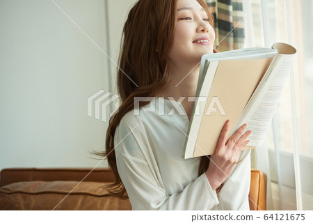 Young woman happy relaxing sunny morning reading 64121675