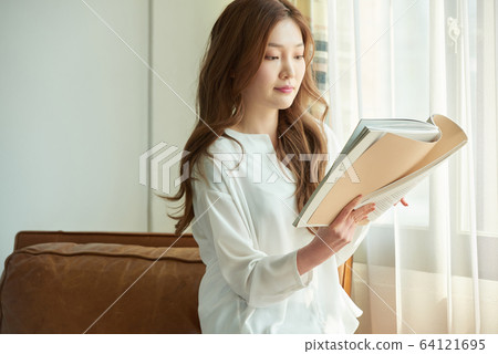 Young woman happy relaxing sunny morning reading 64121695