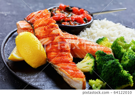 Close-up on roasted salmon steak with lemon wedges 64122010