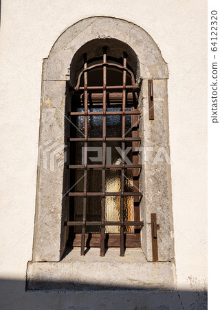Window with wrought iron security bars - Ancient church in Italy 64122320