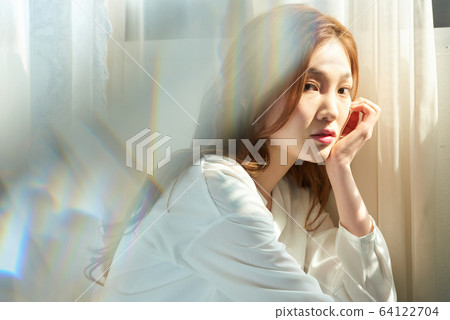 年輕女子窗口陽光美容皮膚美白 64122704
