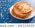 Oat pancakes on a white dish with nuts and syrup, 64123430