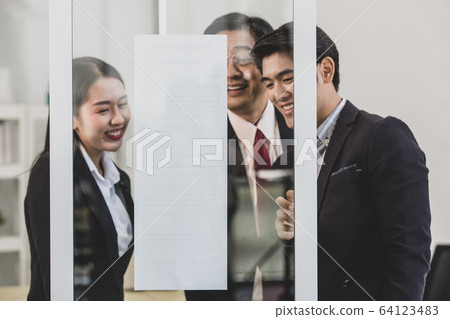 Businesspeople surrounded the placard board. 64123483