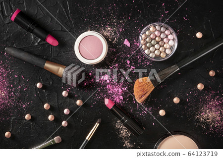 Professional makeup on a black background. Brushes, lipstick and other products, a flat lay with a place for text 64123719