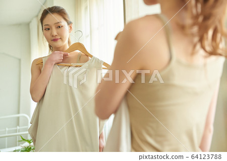 Young woman ready to go out the window mirror clothes happy smile 64123788
