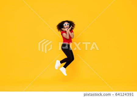 Happy fashionable African American girl jumping 64124391