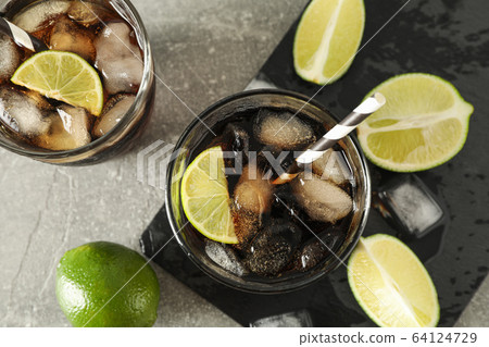 Glasses with cold cola and citrus on grey table, 64124729