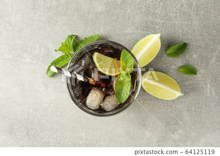 Glasse with cold cola and citrus on grey table, 64125119