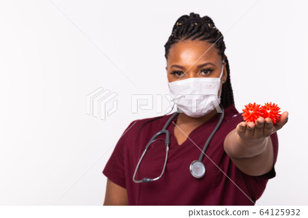 Covid-19, Vaccine development , outbreak and medicine concept - Doctor in medical protective mask holding a model of coronavirus on white background with copy space. Covid-19, Vaccine development , outbreak and medicine concept - Doctor in medical protective mask holding a model of coronavirus on white background with copy space. 64125932