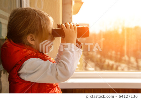 A little cute girl on the balcony with binoculars. A little cute girl on the balcony with binoculars. 64127136