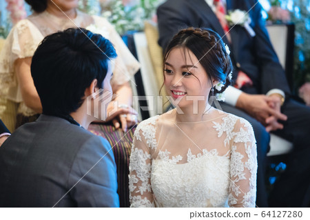 Bride and groom sitting in their wedding 64127280